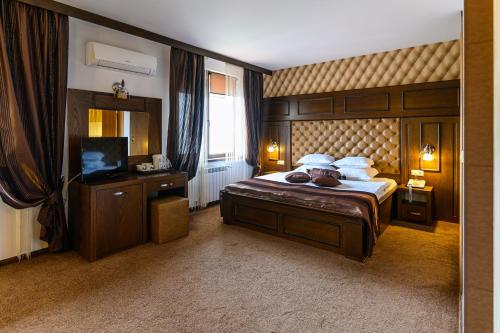 ein Schlafzimmer mit einem großen Bett und einem TV in der Unterkunft Boutique Hotel L do Rado in Sofia