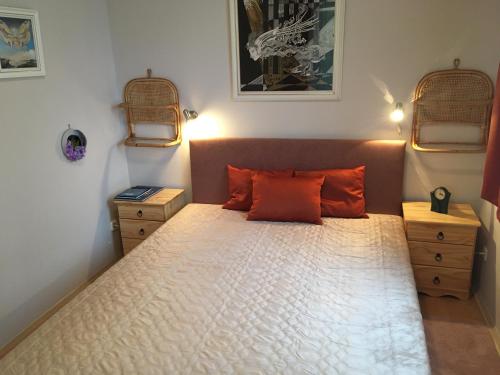 ヘーヴィーズにあるRómai Apartmanházのベッドルーム1室(オレンジ色の枕が付いたベッド1台付)
