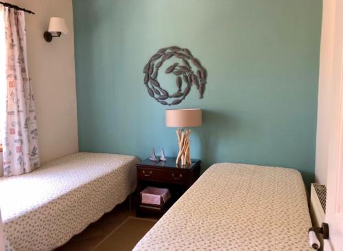 a bedroom with two beds and a lamp on a table at STONE ROSE VILLA in Agios Ioannis