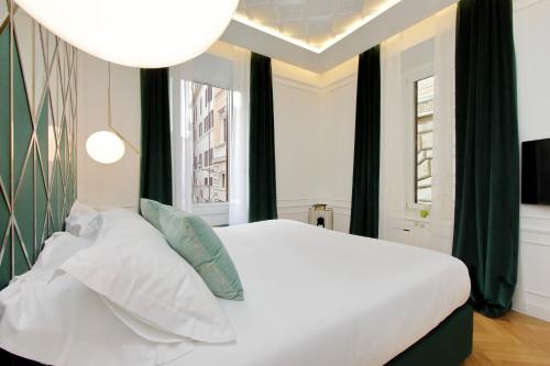 ローマにあるDomna Luxury Suitesの白いベッドと2つの窓がある寝室
