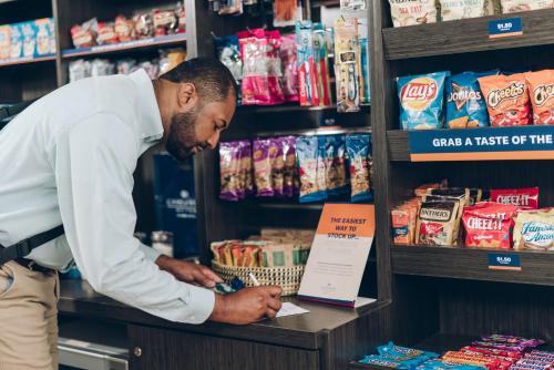 a man standing in a store looking at a shelf at Candlewood Suites Oklahoma City - Bricktown by IHG in Oklahoma City