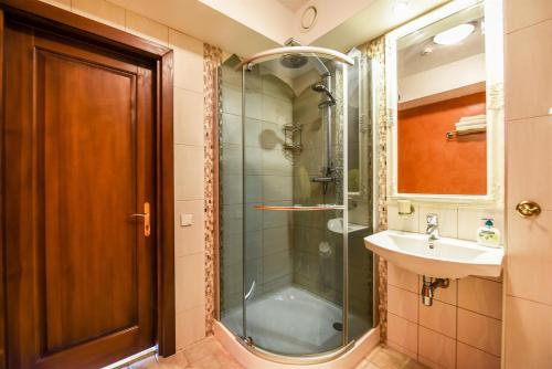 y baño con ducha acristalada y lavamanos. en Villa Regina - Apartment Complex Resort in Šventoji, en Šventoji