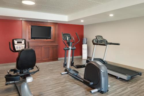 a gym with two exercise bikes and a flat screen tv at Wingate by Wyndham South Bend - Notre Dame in South Bend