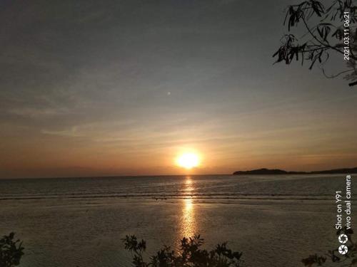 a sunset over the ocean with the sun in the sky at Bolo Beach Santorini nearby to Hundred Island in Alaminos