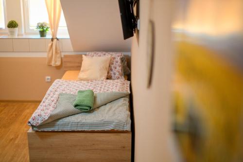 a small bed with pillows on it in a room at Penzion a restaurace Zlatovláska u zámku Červená Lhota in Jižná
