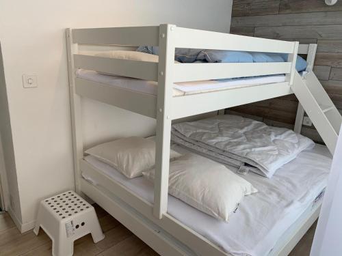 białe łóżko piętrowe z poduszkami w pokoju w obiekcie Roc d'Orsay E48 w mieście Leysin