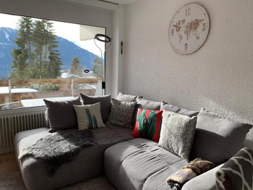 a couch in a living room with a window at Roc d'Orsay E48 in Leysin