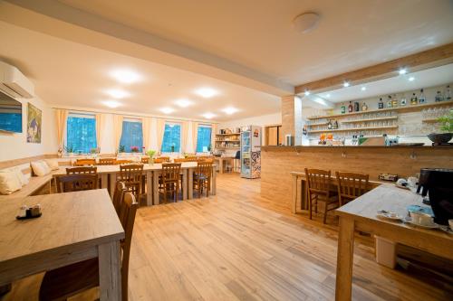 a restaurant with wooden floors and tables and chairs at Penzion a restaurace Zlatovláska u zámku Červená Lhota in Jižná