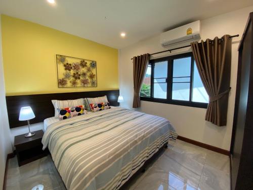 a bedroom with a large bed and a window at YinDee Lanta Villas in Ko Lanta