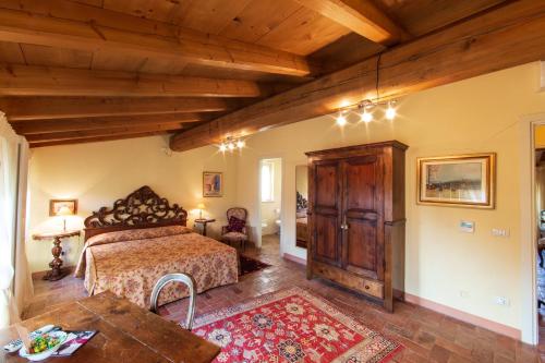 1 dormitorio con cama y techo de madera en Tenuta Delo Relais, en Novaglie