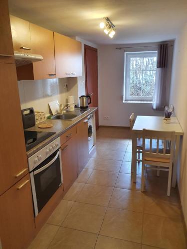 a kitchen with a table and a stove top oven at Chata nad Bystrzykiem - Apartament Karpacz in Karpacz