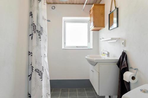 a bathroom with a sink and a toilet and a window at KristiansBorg in Nykøbing Mors