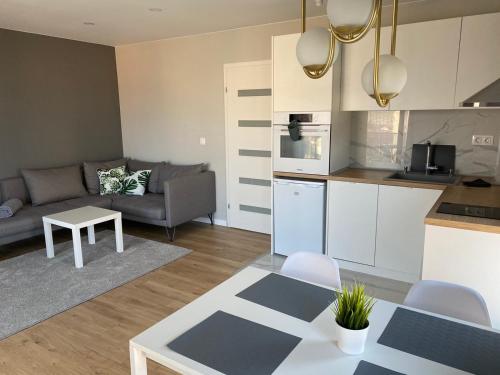 a kitchen and living room with a couch and a table at TheHouse - Apartment Kamenitza in Velingrad