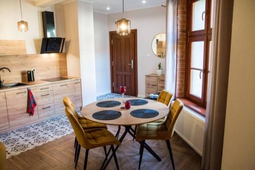 a kitchen with a table and chairs in a room at Gold Garden by Rentoom in Toruń