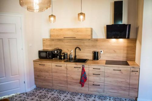 a kitchen with a sink and a microwave at Gold Garden by Rentoom in Toruń