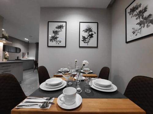 a dining room with a table with plates and cups at Rezydencja Biały Dworek in Wisła