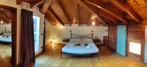a bedroom with a bed in a room with wooden ceilings at The Lake Apartment in Colico