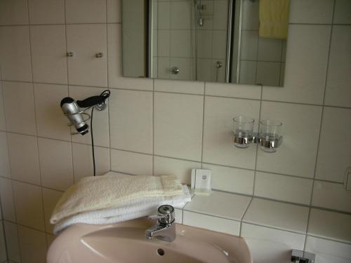a bathroom with a sink and a mirror and a towel at Hotel Gasthaus Zum Hirschen in Simonswald