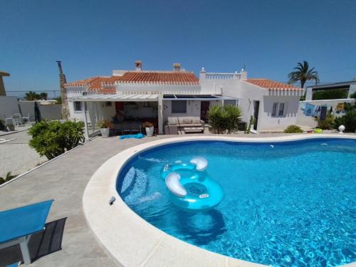 basen z niebieską tratwą w domu w obiekcie VILLA DOS-LAGOS w mieście Torrevieja