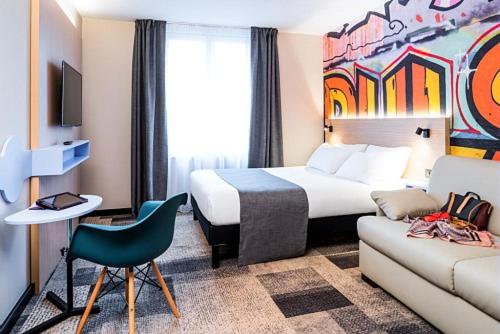 ein Hotelzimmer mit einem Bett und einem Sofa in der Unterkunft ibis Styles Clamart Gare Grand Paris in Clamart