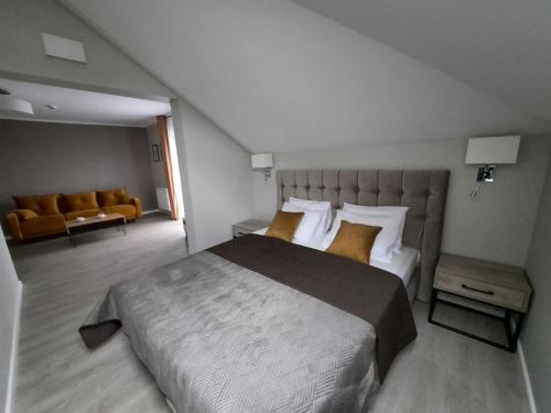 a bedroom with a large bed and a couch at Rezydencja Biały Dworek in Wisła