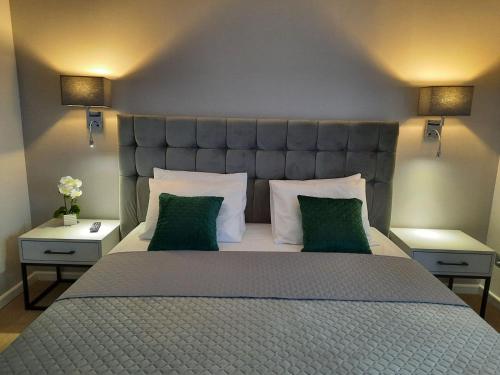 a bedroom with a large bed with two green pillows at Rezydencja Biały Dworek in Wisła