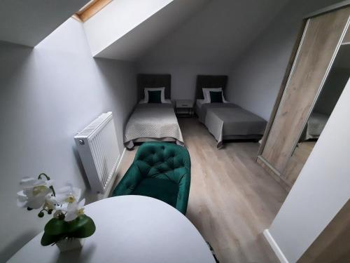 a room with two beds and a green couch at Rezydencja Biały Dworek in Wisła