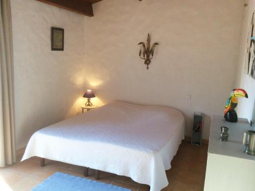 ein Schlafzimmer mit einem weißen Bett in einem Zimmer in der Unterkunft Maison 4 adultes et 4 enfants - 250m de la plage in La Guérinière