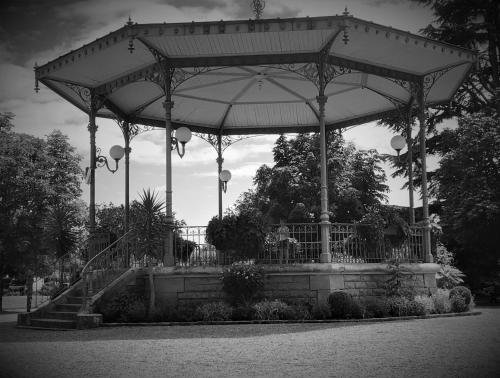 a large gazebo with an umbrella in a park at La Tour de la Conterie in Beaumont-Village