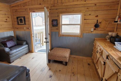 une chambre avec un canapé et une chaise dans une cabine dans l'établissement Stay In Current, à Jadwin