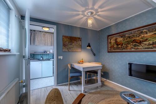 a living room with a table and a kitchen at B&B Larenstein logeren in een tiny house in Velp