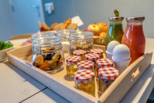 a tray of food with jars of honey and fruit at B&B Larenstein logeren in een tiny house in Velp