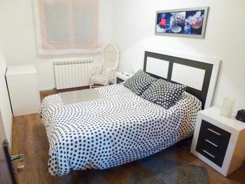 1 dormitorio con 1 cama en blanco y negro y 1 silla en Apartamentos Formigal - admite mascotas, en Formigal