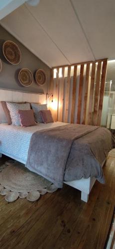 a bedroom with a large bed with a wooden headboard at Les Chalets Du Goulet in Le Bleymard