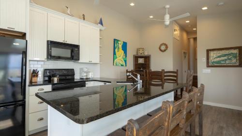 a kitchen with white cabinets and a black counter top at Sea Crest in Amagansett