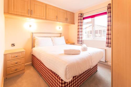 a small bedroom with a bed and a window at Saffron Lodge With Hot Tub in Malton