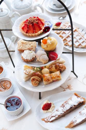 a table topped with three plates of pastries and desserts at Hotel Ritta Höppner in Gramado