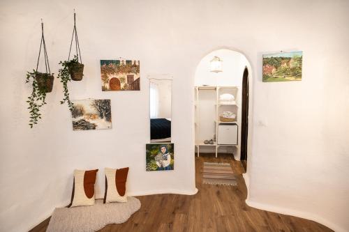 a hallway with a white wall with pictures on it at Pensiunea Dealul Verde in Porumbacu de Sus