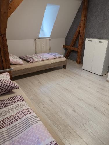 a room with two beds and a refrigerator at Ferienwohnung Rote-Villa in Pobershau