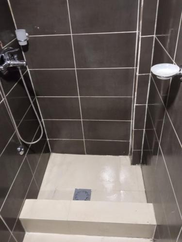 bagno con doccia piastrellata e servizi igienici di Monte room a Podgorica