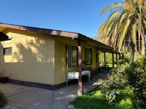 a small yellow house with a table in front of it at Paine - Hermosa Parcela de Agrado in Santiago