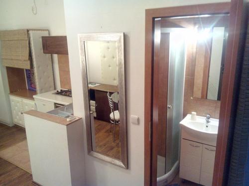ein Badezimmer mit einem Spiegel und einem Waschbecken in der Unterkunft Collins Apartments in Pula