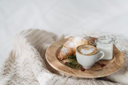 a plate of food with a cup of coffee and croissants at Hotel Chalet Del Brenta in Madonna di Campiglio