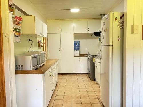 a kitchen with white cabinets and white appliances at Paine - Hermosa Parcela de Agrado in Santiago