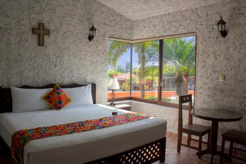 1 dormitorio con cama y ventana grande en Camino Mexicano Hotel & Resort en Tuxtla Gutiérrez