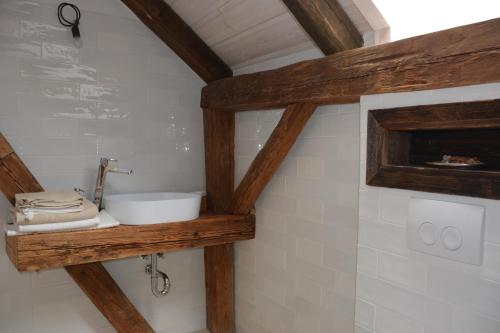 a bathroom with a sink on a wooden shelf at Penzion Okamžik Stanovice in Nová Cerekev