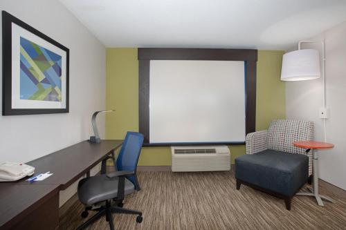 an office with a desk and two chairs and a screen at Holiday Inn Express Hotel & Suites Longmont by IHG in Longmont