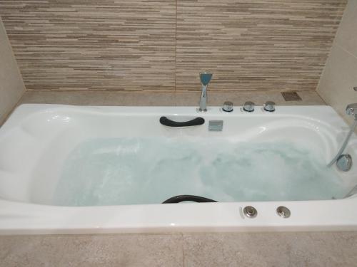 a white bath tub with a faucet in a bathroom at Stylish home - comfortable holidays near the beach. in Panormos Rethymno