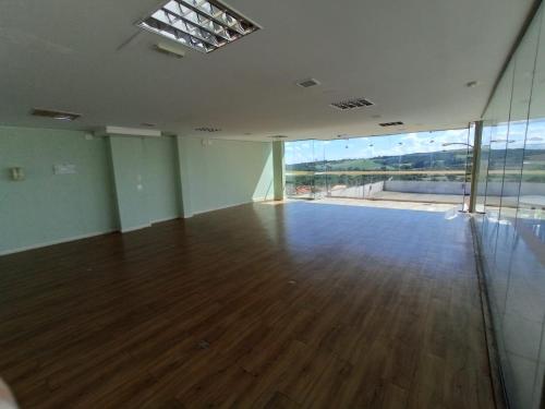 an empty room with a wooden floor and a large window at Hotel Manacá in Sacramento