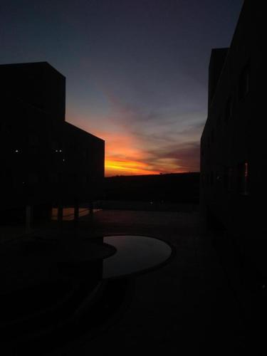 a sunset with the sun setting behind some buildings at Hotel Manacá in Sacramento